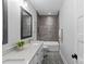 Bathroom with gray tiling, double vanity, and mirror with modern fixtures at 5638 Timber Ln, Charlotte, NC 28270