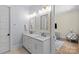 Bathroom with double vanity sinks, decorative mirrors, and access to the bedroom at 5638 Timber Ln, Charlotte, NC 28270