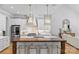 Open kitchen boasts a large island with counter seating and modern gold lighting fixtures at 5638 Timber Ln, Charlotte, NC 28270