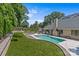Backyard view featuring a pristine pool, green lawn, and elegant patio with outdoor seating at 5638 Timber Ln, Charlotte, NC 28270
