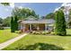 Charming brick home featuring a welcoming front porch, manicured lawn, and mature landscaping at 628 Stamie Dr, Chester, SC 29706