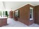 Covered porch with brick columns, seating, and a view of the landscaped front yard at 628 Stamie Dr, Chester, SC 29706