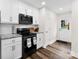 Well-lit kitchen with white cabinets, granite countertops, and black stainless steel appliances at 7144 Marlin St, Gastonia, NC 28056
