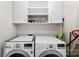 Bright laundry room features a washer and dryer, along with upper cabinets and shelving at 7144 Marlin St, Gastonia, NC 28056