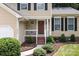 Inviting front porch with neat landscaping, a red front door and manicured shrubs at 7212 Morsey Ct, Charlotte, NC 28269