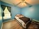 Bedroom featuring a window, ceiling fan, wood-look floors, and a bed with floral sheets and a brown blanket at 7267 Sandown Ct, Harrisburg, NC 28075