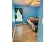 A cozy bedroom with blue walls, wood-look flooring, a ceiling fan, and a window with dark curtains at 7267 Sandown Ct, Harrisburg, NC 28075