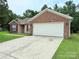Charming brick and vinyl home featuring an expansive driveway and two car garage at 7267 Sandown Ct, Harrisburg, NC 28075