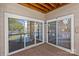 Enclosed wooden balcony featuring sliding glass doors with a peaceful lake view at 7845 Village Harbor Dr, Cornelius, NC 28031