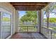 Scenic lake view from wood balcony, showcasing mature trees and tranquil waterfront at 7845 Village Harbor Dr, Cornelius, NC 28031