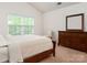 Relaxing bedroom features a bright window, wooden dresser, and neutral decor at 8953 Bradstreet Commons Way, Charlotte, NC 28215