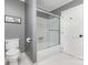 Bathroom featuring white tile, a shower with a glass door, toilet, and gray walls at 905 Mangionne Dr, Matthews, NC 28105