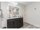 Updated bathroom features a dark vanity with a marble countertop and a large, illuminated mirror at 905 Mangionne Dr, Matthews, NC 28105