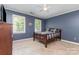 Bedroom with blue walls, two large windows, a ceiling fan, and a wood-frame bed with plaid linens at 905 Mangionne Dr, Matthews, NC 28105