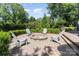 Backyard with a paver patio and cozy stone fire pit surrounded by Adirondack chairs at 905 Mangionne Dr, Matthews, NC 28105