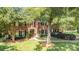 Stately two-story brick home with mature trees, a manicured lawn, and a welcoming front entrance at 905 Mangionne Dr, Matthews, NC 28105