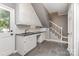 Functional laundry room boasts ample white cabinets, counter space, a sink, and adjacent stairs at 905 Mangionne Dr, Matthews, NC 28105