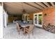 Covered patio features brick walls, stone flooring, hot tub, and a dining table for entertaining at 905 Mangionne Dr, Matthews, NC 28105
