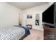 Well-lit bedroom featuring a cozy bed, mounted TV, and a convenient luggage rack, blending comfort and functionality at 9274 Dunwich Dr, Gastonia, NC 28056