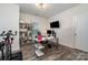 A well-lit home office with modern decor, a large desk, modern shelving and exercise equipment at 9274 Dunwich Dr, Gastonia, NC 28056