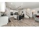 Open concept kitchen featuring white cabinets, stainless steel appliances, and adjacent living area with staircase at 9274 Dunwich Dr, Gastonia, NC 28056