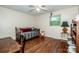 Well-lit bedroom with hardwood floors, a ceiling fan, and a cozy daybed by the window at 928 Tally Ho Ct, Charlotte, NC 28212