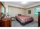 Comfortable bedroom with carpeted floors, a decorative bedspread, and natural light from the window at 928 Tally Ho Ct, Charlotte, NC 28212