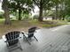 An outdoor deck with chairs surrounded by trees and greenery at 103 Boyd Dr, Stanley, NC 28164
