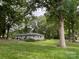 Expansive backyard with mature trees and a house with a patio in the background at 103 Boyd Dr, Stanley, NC 28164