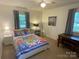 Comfortable bedroom with a floral quilt, desk, and ample natural light at 103 Boyd Dr, Stanley, NC 28164