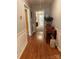 View of a hardwood hallway featuring detailed trim and an antique table holding floral arrangements at 103 Boyd Dr, Stanley, NC 28164