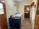 Laundry room with a window, washer, dryer, blue dresser, and access to another bathroom at 103 Boyd Dr, Stanley, NC 28164