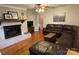 Cozy living room with a white brick fireplace, hardwood floors, and comfortable seating at 103 Boyd Dr, Stanley, NC 28164