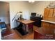 This home office features wood-paneled walls, hardwood floors, and ample space for a desk and storage at 103 Boyd Dr, Stanley, NC 28164