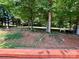 Landscaped backyard with lush trees, picnic table, terraced planting bed and a shady bench at 1031 Daniel Dr, Stanley, NC 28164