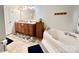 Bright bathroom featuring a soaking tub, vanity with drawers, tile flooring, and functional layout at 1031 Daniel Dr, Stanley, NC 28164