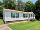 Inviting single-story home with a well-manicured lawn, tidy brick foundation, and green shutters at 1031 Daniel Dr, Stanley, NC 28164