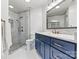 Modern bathroom featuring a walk-in shower with marble walls and a blue vanity with gold fixtures at 1038 Southwest Dr, Davidson, NC 28036