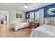 Bright bedroom with twin beds, blue accent wall, and a view of the outdoor scenery at 1038 Southwest Dr, Davidson, NC 28036