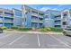 Blue condo building with multiple balconies, reserved parking spaces, and landscaping at 1038 Southwest Dr, Davidson, NC 28036