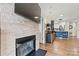 View of the living room featuring a modern fireplace, mounted television, and a glimpse into the kitchen at 1038 Southwest Dr, Davidson, NC 28036