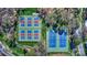 Aerial view of tennis courts with blue and red surfaces, surrounded by trees at 1038 Southwest Dr, Davidson, NC 28036