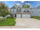 Charming two-story home featuring a stone facade, a three-car garage, and a manicured front yard at 1054 Thoroughbred Dr, Iron Station, NC 28080