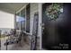 Inviting front porch with seating, a welcoming wreath on a black door, and a decorative 'Bless This Home' sign at 1054 Thoroughbred Dr, Iron Station, NC 28080
