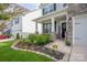 Inviting front porch with stone accents, landscaped flower bed, and a 'Bless This Home' sign at 1054 Thoroughbred Dr, Iron Station, NC 28080
