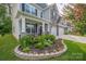 Charming front yard featuring a landscaped flower bed, well-maintained lawn, and covered front porch at 1054 Thoroughbred Dr, Iron Station, NC 28080