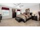 Spacious primary bedroom featuring a ceiling fan, decorative pillows, and carpeted floors at 1054 Thoroughbred Dr, Iron Station, NC 28080