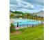 Community pool featuring ample seating, a splash pad, and beautiful landscaping at 1054 Thoroughbred Dr, Iron Station, NC 28080