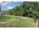 Spacious backyard featuring a lush lawn, privacy fence, and mature trees, perfect for outdoor activities and relaxation at 12829 Brandenburg Ln, Midland, NC 28107