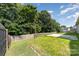 The backyard features a grass lawn, mature trees, and partial fence at 12829 Brandenburg Ln, Midland, NC 28107